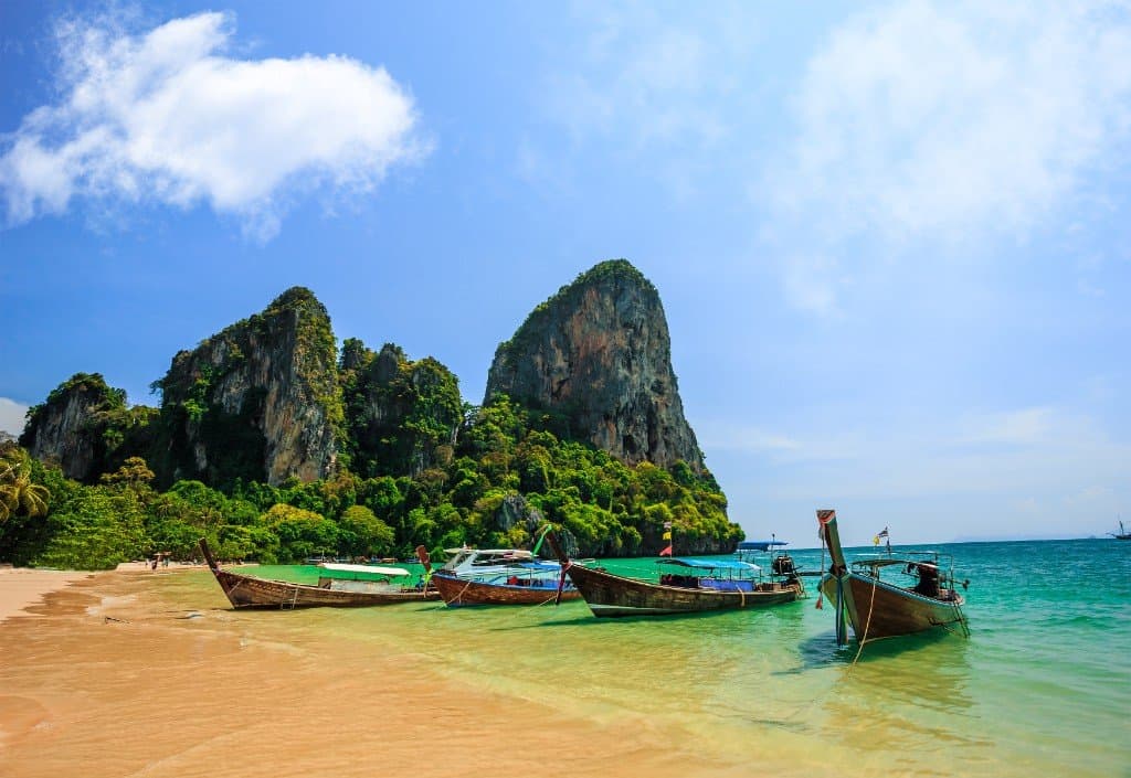 Railay West Beach with long-tail boats and limestone cliffs on the Andaman Sea, Krabi